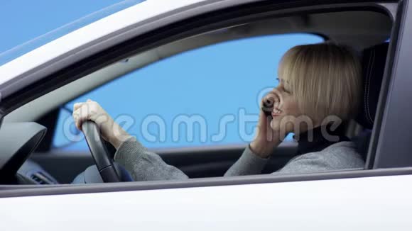 金发的快乐女人穿着休闲装驾驶着绿色屏幕背景的汽车4她正坐在车上喝着酒视频的预览图