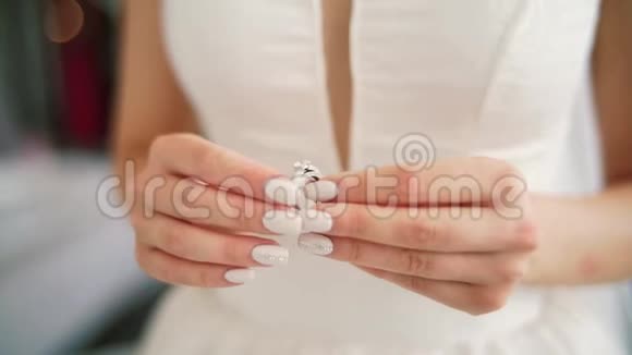 女手用银色金戒指钻石架聚焦女人戴着订婚戒指手指打磨指甲视频的预览图