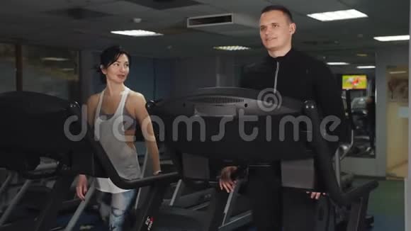 男人和女人一起在运动俱乐部的跑步机上训练视频的预览图