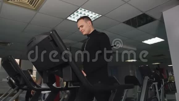 男运动员在健身房锻炼一个男人在运动俱乐部的跑步机上训练视频的预览图