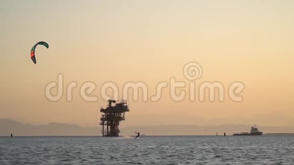 日落时分基瑟夫正在海上乘风破浪身后是石油钻井平台视频的预览图