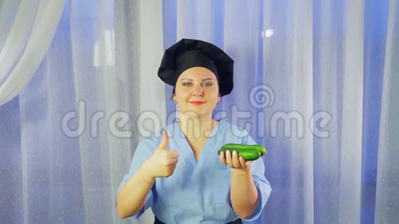 女厨师穿着围裙微笑着手里拿着黄瓜向全班同学展示视频的预览图