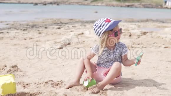 孩子玩沙子小女孩在海滩上玩耍视频的预览图