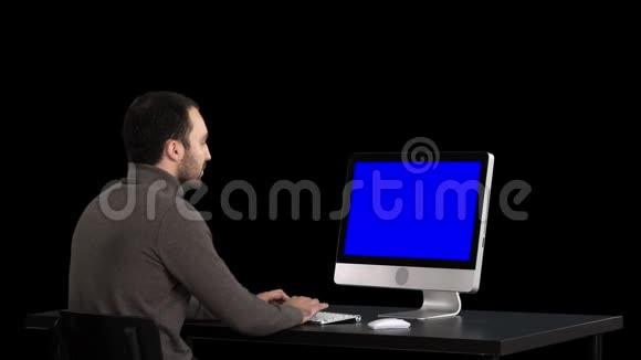男人在电脑上打字阿尔法频道蓝屏模拟显示视频的预览图