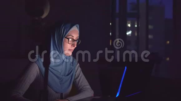 戴眼镜戴头巾带笔记本的穆斯林女孩视频的预览图