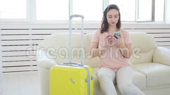 旅行旅行和度假概念带黄色手提箱的女人正在等出租车视频的预览图