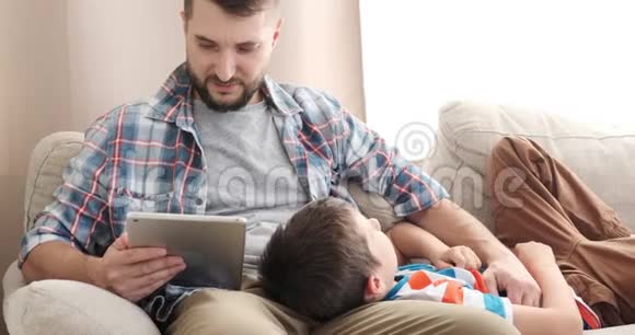 父亲给儿子读电子书让他在家里放松视频的预览图