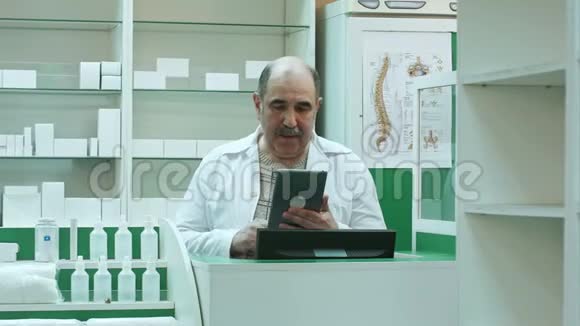 高级药剂师在药店使用平板电脑与客户进行视频聊天视频的预览图