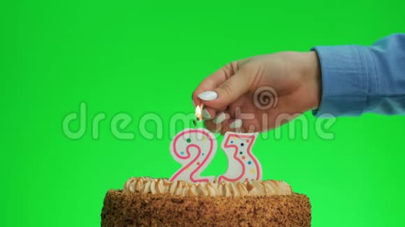 在美味的蛋糕上点燃二十三岁生日蜡烛绿色屏幕23视频的预览图