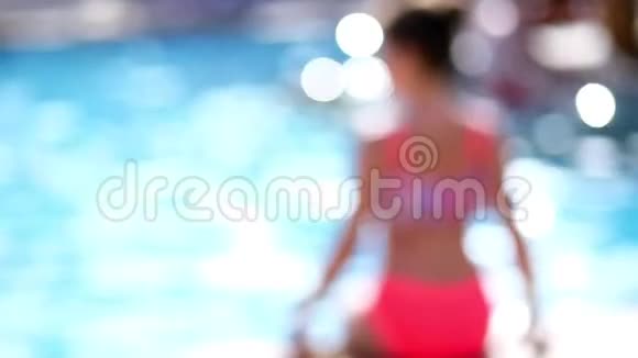 模糊失去焦点夏天阳光明媚的一天一个十几岁的女孩穿着鲜艳的泳衣在游泳池里休息日光浴视频的预览图