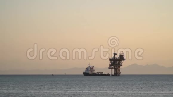 大船停靠在海上的石油钻井平台上雾蒙蒙的背景视频的预览图
