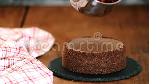 女人用樱桃酱装饰巧克力芝士蛋糕视频的预览图