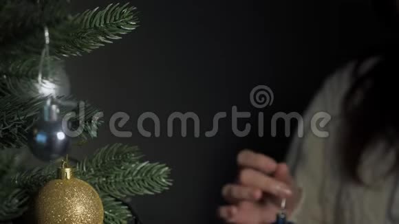 女士拿着圣诞装饰品戴上人造树视频的预览图
