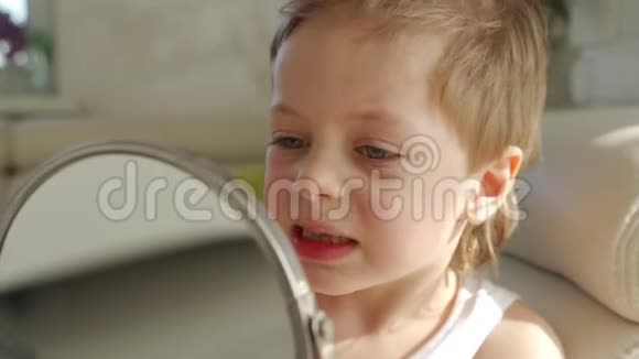 一个金发碧眼的小男孩张开嘴对着镜子看他的一颗牙齿掉哪里视频的预览图