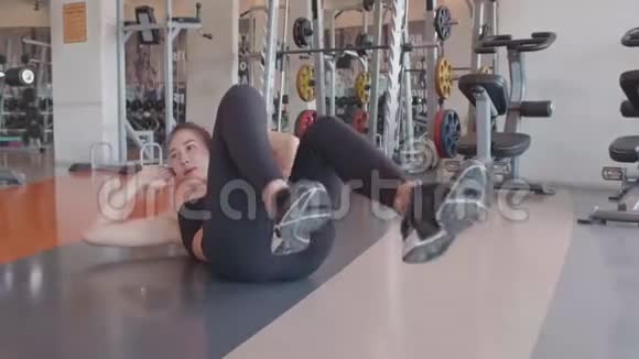 运动女人在健身馆里骑自行车嘎吱作响地坐在地板上人们的生活方式和锻炼体育训练俱乐部活动视频的预览图