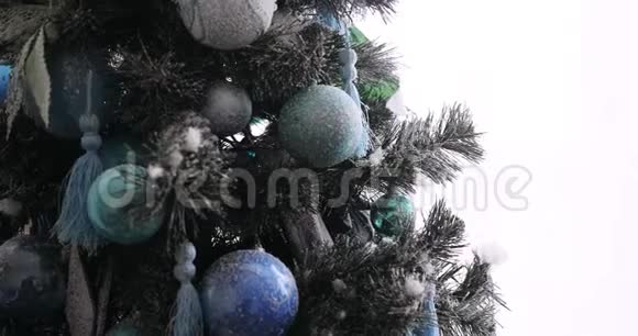 女人装饰圣诞树挂装饰球在树枝上双手特写视频的预览图