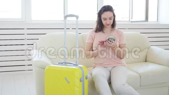 旅行旅行和度假概念带黄色手提箱的女人正在等出租车视频的预览图