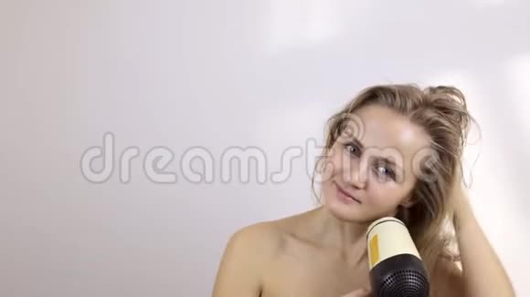 金发美女关心头发吹干头发视频的预览图
