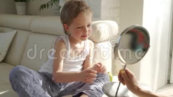 一个金发碧眼的小男孩张开嘴对着镜子看他的一颗牙齿掉哪里视频的预览图