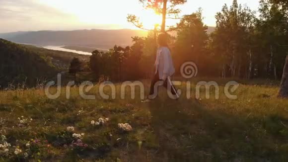 日落时分幸福的年轻夫妇在山上散步视频的预览图