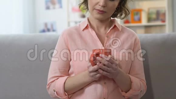沮丧的女人喝着咖啡看着镜头正在经历中年危机视频的预览图