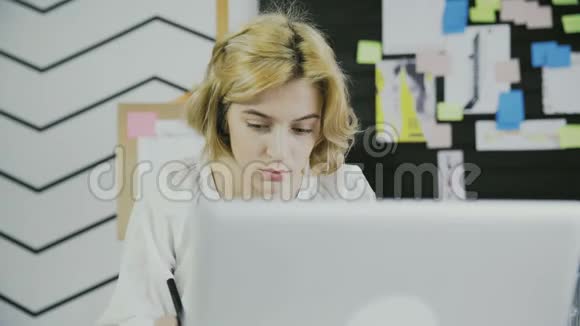欧洲妇女在现代办公室用笔记笔记的特写镜头视频的预览图