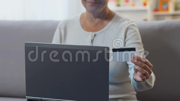 女性将信用卡数据输入笔记本电脑在线支付水电费视频的预览图