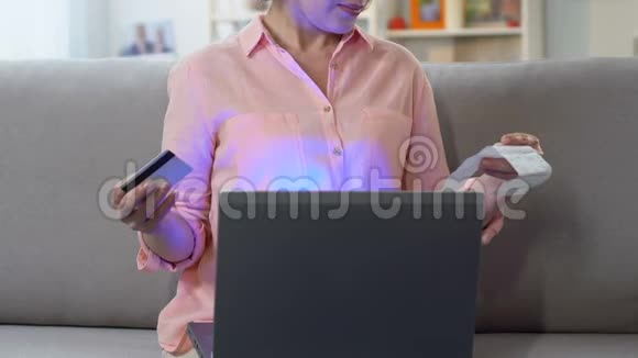 女士在笔记本电脑上用信用卡支付支票方便在线纳税视频的预览图