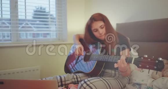 美丽的少年女孩在卧室里弹吉他感觉很好享受放学后的放松时光视频的预览图