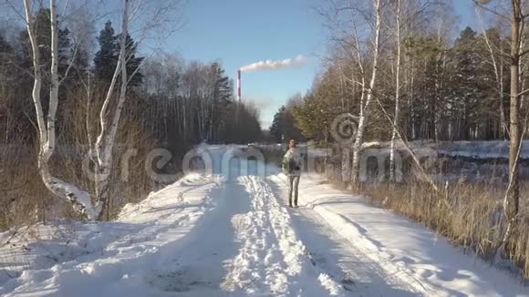 空中小姐扛着松树沿着被雪覆盖的道路走视频的预览图