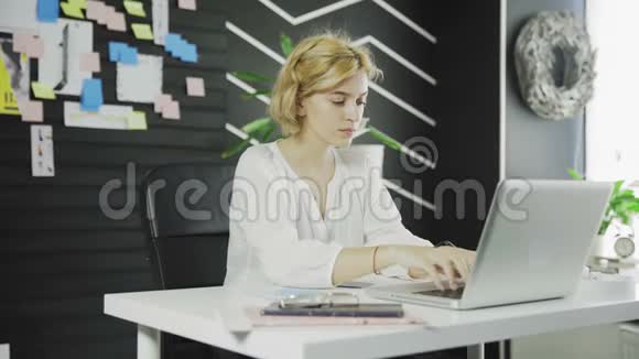 快乐的商业女人完成了她的工作桌子上的腿视频的预览图
