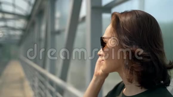 一个戴眼镜的女人站在金属结构的背景上视频的预览图
