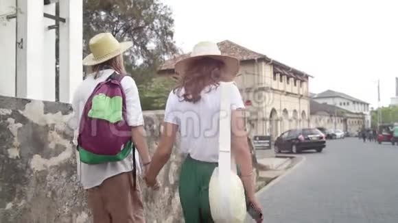 年轻时尚的戴草帽的情侣正在大街上散步视频的预览图