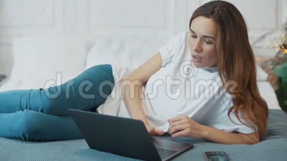 严肃的商务女性在豪华卧室里看电脑屏幕视频的预览图