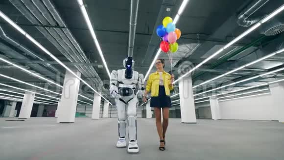 白色机器人和一个女人一起走牵着她的手视频的预览图