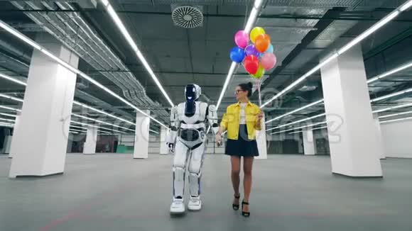 一个女人手里拿着气球和半机械人一起在房间里散步视频的预览图