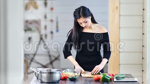 自信的亚洲年轻女性用刀切有机蔬菜做健康的新鲜沙拉视频的预览图