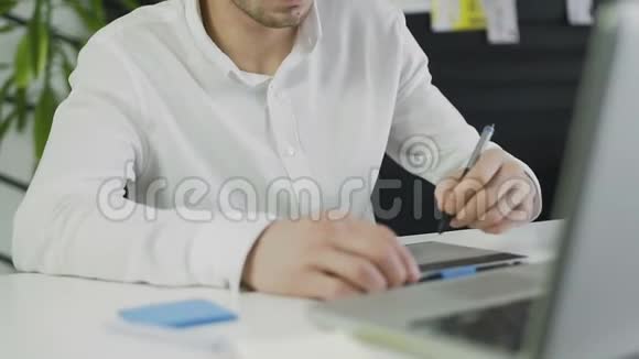 休闲男性设计师在明亮的办公室里使用图形平板电脑视频的预览图