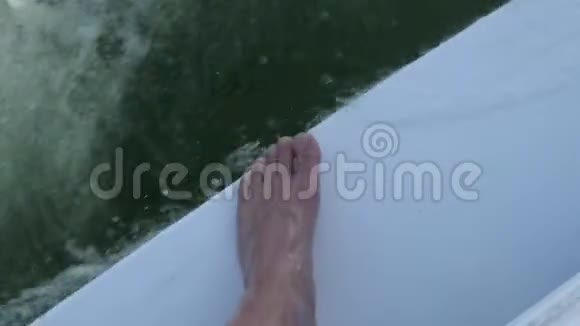 一波水一个人的脚在一条小溪的水上在一条小船上泡沫在水上视频的预览图