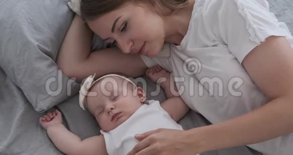 妈妈带着可爱的女儿睡在床上视频的预览图