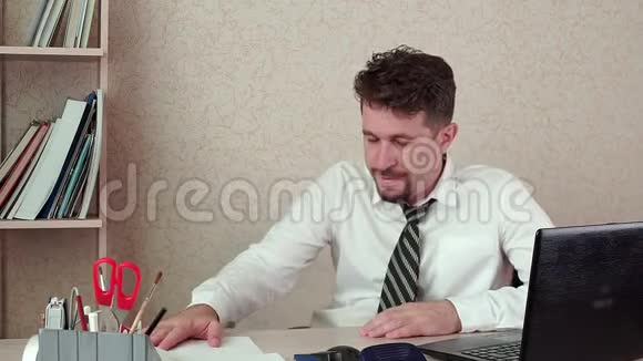 累的经理在笔记本电脑上工作他办公室很累想回家视频的预览图