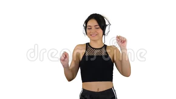 穿着短裤和耳机在白色背景上跳舞的迷人女孩视频的预览图