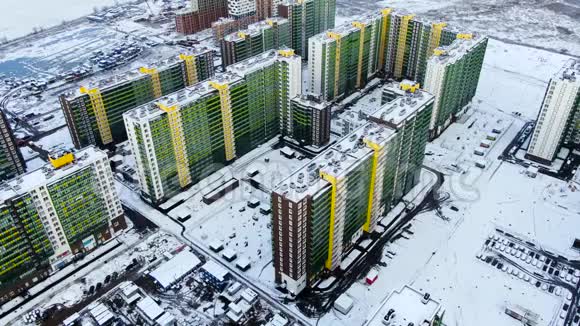 冬季城市景观空中有新的住宅建筑和被雪覆盖的地面动作鸟瞰景色视频的预览图