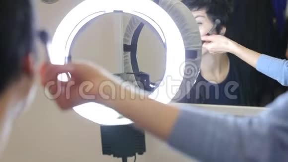 镜子前的女孩用刷子化妆视频的预览图