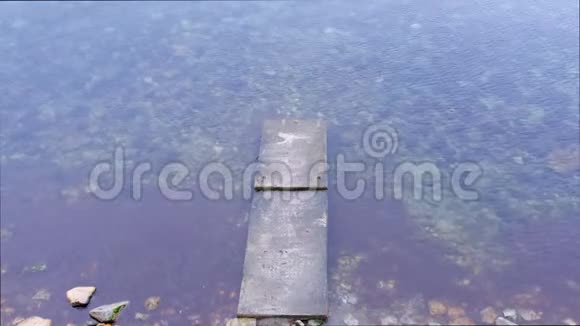 旧混凝土破坏码头在海上透明的水与海藻视频的预览图