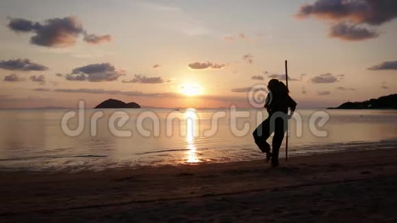 一位年轻有权势的女人在海滩上做功夫练习的剪影视频的预览图