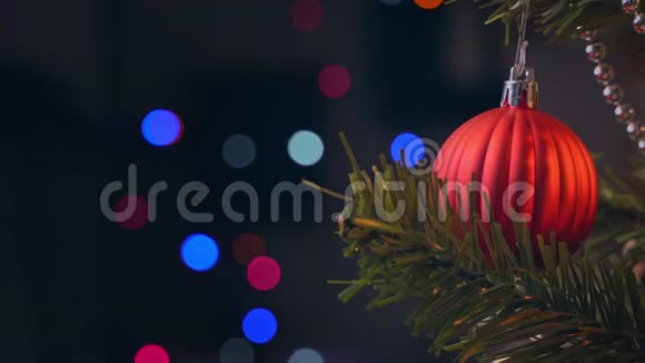 美丽的装饰圣诞树与悬挂的宝布尔和闪闪发光的LED串灯照明点在黑暗黑色背景麦克尔视频的预览图