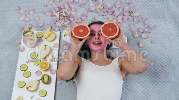 微笑的年轻女子在相机上摆着葡萄柚同时在健康中心放松视频的预览图