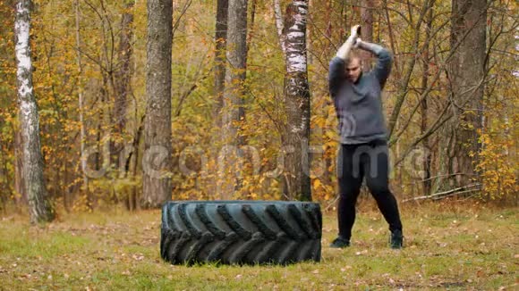 一个大个子健美运动员撞到卡车轮胎秋林视频的预览图