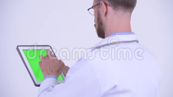 留胡子男医生使用数码平板电脑的后视图视频的预览图